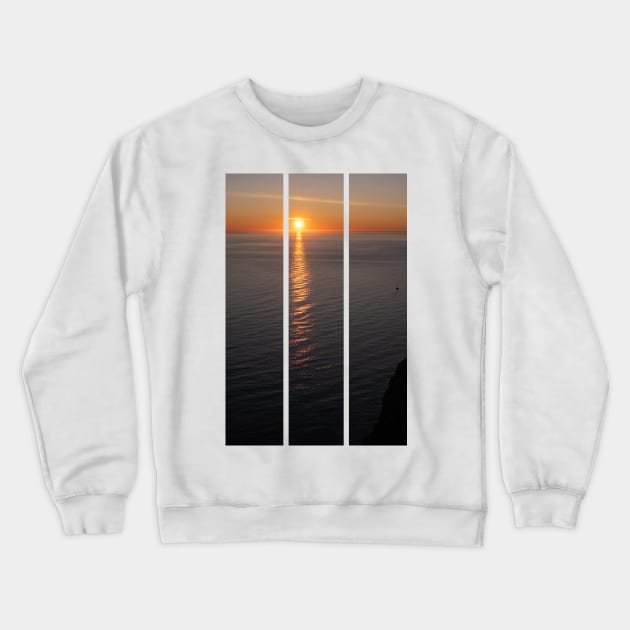 Wonderful landscapes in Norway. Nord-Norge. Beautiful scenery of a midnight sun sunset at Nordkapp (Cape North). Boat and globe on a cliff. Rippled sea and clear orange sky. (vertical) Crewneck Sweatshirt by fabbroni-art